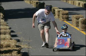 Ben Souland, 6, gets some help from his dad, Jeff, getting to the finish line during the soapbox derby in front of Essex Elementary School.Ben had a little trouble steering his soapbox car, weaving in and out of the lanes. Photo by Mary Muckenhoupt/Gloucester Daily Times, Saturday, Sept. 29, 2007