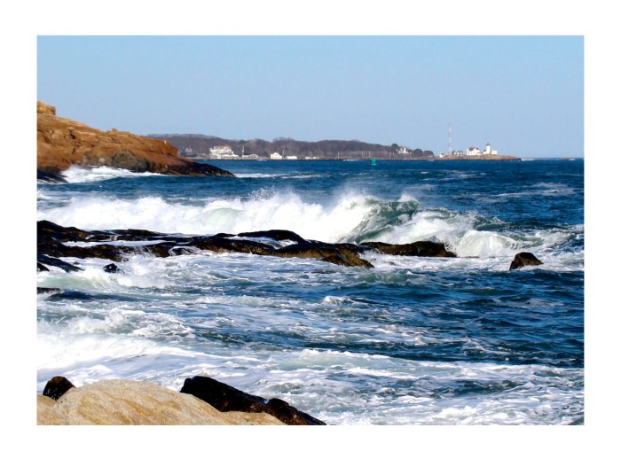 waves crashing on rocks of Magnolia with Eastern Point Light in the distance