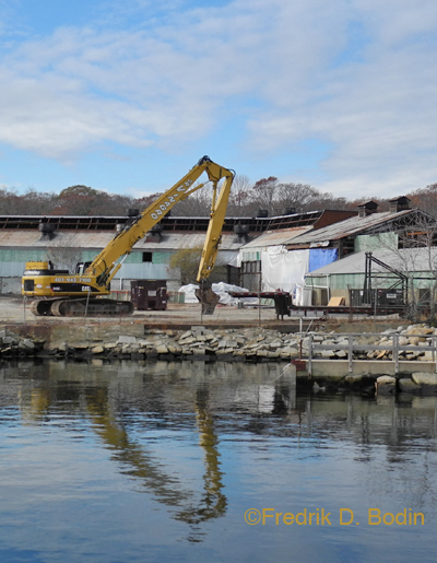 Photo taken November 16, 2013. It took months for workers to jackhammer the tower down to a height within reach of the excavator (foreground), which finished the job in short order.