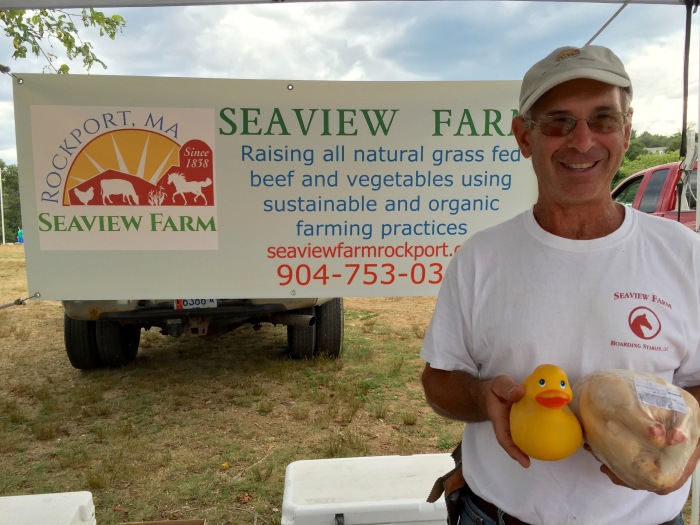 Ken from Seaview Farm at Cape Ann Farmers Market on Thursday. Meet him and the chicken that he is holding at the Rockport Farmers Market. (Chicken is in his left hand.)