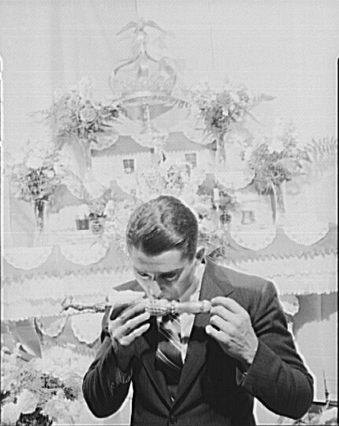 Frank Domingos kissing a vessel representing remains of a saint, during ceremonies at his father's home, part of the tri-annual fiesta of Pentacost. The celebration--including the chosing of an Imperator, and
