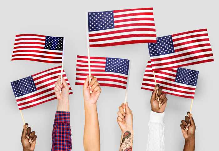 close up photo of people holding usa flaglets